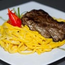 Foto de tallarín a la huancaína con lomo liso.$ 9.000