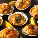 Foto de Almejas rellenas con espuma de mantequilla con merken y chips de albahaca y una mini ensalada.