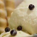 Foto de Helado de chirimoya, salsa toffe y mini empolvados, plátanos flambeados y geele de manjar.