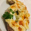 Foto de tripa de vaca , rellena con , carne , arroz , condimento , acompañada de hummus , cebolla cruda y pan