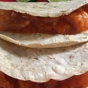 Foto de Taco de chicharrón delgado en salsa roja.