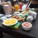 Foto de 4.	Café, jugo, tostadas con huevo revuelto con jamón cocido ,queso crema y palta pisada.