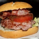 Foto de Hamburguesa de secreto ibérico, crujiente de jamón, cebolla caramelizada, lechuga, tomate y emmental