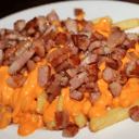 Foto de Patatas fritas con queso cheddar y dados de bacon braseado 