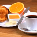 Foto de Café con leche o infusión + Jugo de naranja + Tostadas + Queso crema, mermelada y dulce de leche.