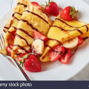 Foto de Crepe de fresas y banano con chocolate y crema chantilly