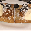 Foto de Waffle dulce con un topping, crema batida o yogurt y una salsa