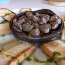 Foto de Carne al ajillo (280gr) con tostadas al ajo , mozzarellay pesto, papas rústicas.