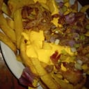 Foto de papas fritas con cheddar 