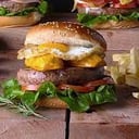 Foto de A LO POBRE: hamburguesa artesanal de carne, acompañado de plátano frito, huevo a la inglesa y crujientes papas nativ