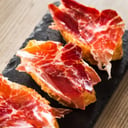 Foto de PORCIÓN DE JAMÓN SERRANO CORTADO DE LA PIERNA CON PAN Y TOMATES RALLADOS
