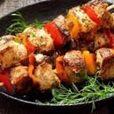 Foto de Brochetas Mar y Tierra acompañado de papas rústicas y salsa de ajo cilantro.