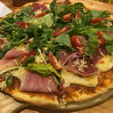 Foto de Pizza de muzzarella, jamón crudo y rúcula
