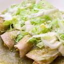 Foto de Enchiladas verdes rellenas con pollo, lechuga, crema y queso acompañadas con frijoles