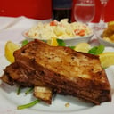 Foto de asado costillar con papas fritas o ensalada mixta