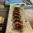 Foto de Tataki atún sobre cama de tomate de árbol y ponzu.