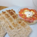 Foto de 2 tostadas de pan casero integral con huevo revuelto tomate y queso crema