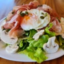 Foto de Jamón crudo, champignones frescos, huevo soft, semillas sobre mix de verdes (keto)