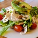 Foto de Veggie: tomates cherries, champignones frescos, palta, almendras, semillas sobre mix de verdes y rúcula (vegana) (keto)