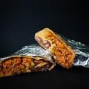 Foto de BURRITO PASTOR. En tortilla de yuca. Cerdo al pastor, trozos de piña, frijolitos, queso mozzarella,