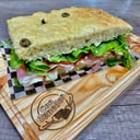 Foto de Focaccia (jamon crudo, queso, rucula, tomate, untado con queso crema.)