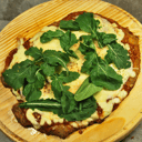 Foto de Pizzanesa de rucula, parmesano y provolone.