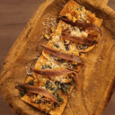 Foto de Tostas de Anchoas de Santoña La Machina sobre wanton, mirepoix de tomate raff, pesto de cacahuete y pecorino romano -5 unds-