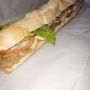 Foto de sanguchazo de milanesa de queso, jamon, tomate, lechuga, huevos y cheddar