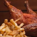 Foto de 2 Pollos al spiedo con una guarnicion