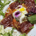 Foto de Ensalada de burrata con gazpacho de sandía, torrezno, picatoste, polvo de pistacho, cherry asado y aceite de Olibaeza