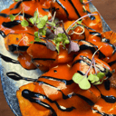 Foto de Bravas de boniato asado con crema de chile torrado y emulsión de ajo negro