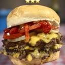 Foto de triple campeona ( triple medallon, sextuple cheddar, tomate, cebolla, mayonesa de morron)