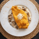 Foto de Milanesa de pollo sobre risotto de hongos