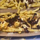 Foto de Patatas fritas y gratinadas con mozzarella, beicon, emulsión de huevo frito y cebolla crujiente